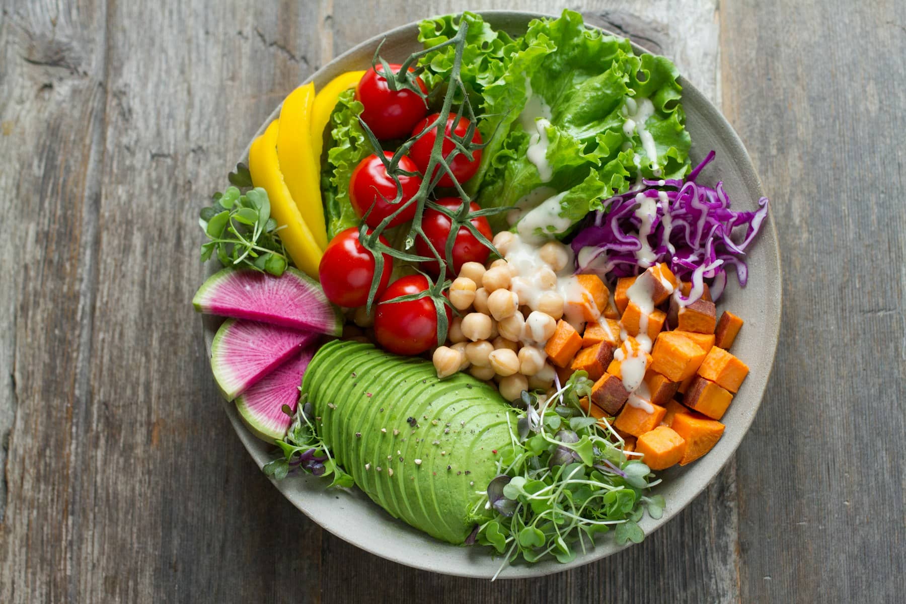 Prato colorido com legumes, grãos, abacate e folhas frescas
